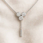 necklace with three round diamonds on a beige background