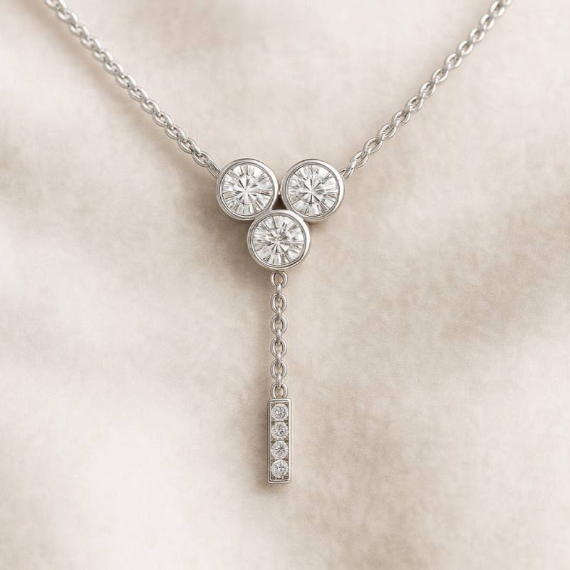 necklace with three round diamonds on a beige background