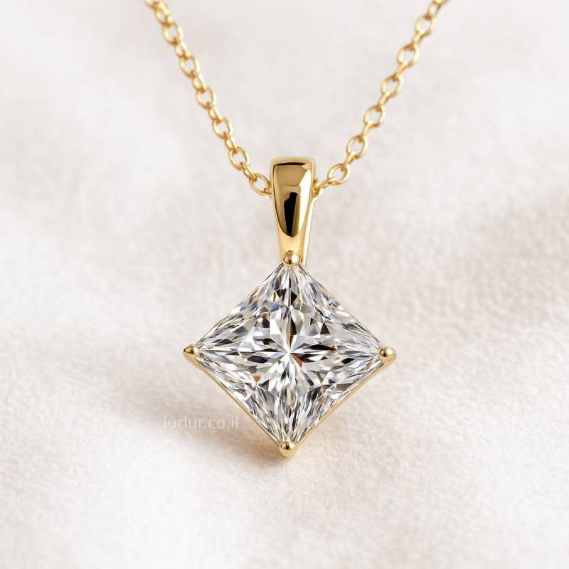 Gold necklace with a square-cut diamond pendant on a light background