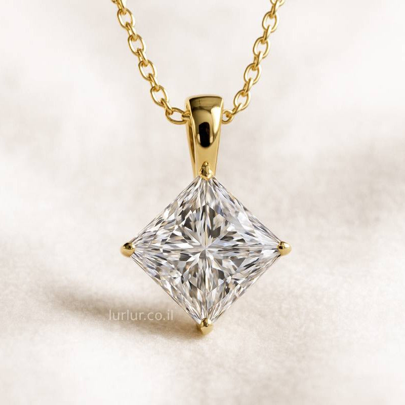 Gold necklace with a clear diamond pendant on a light background
