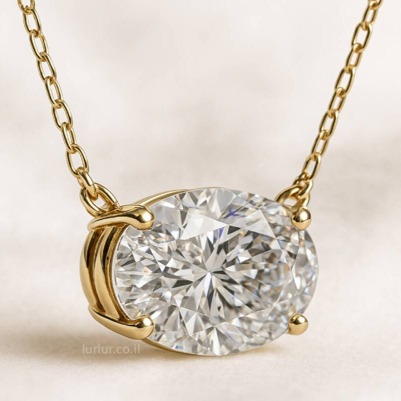 Gold necklace with a diamond pendant on a light beige background
