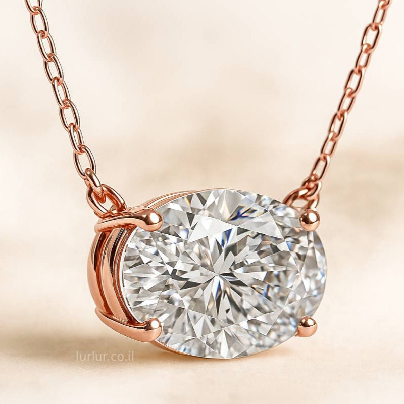Rose gold necklace with a diamond pendant on a beige background