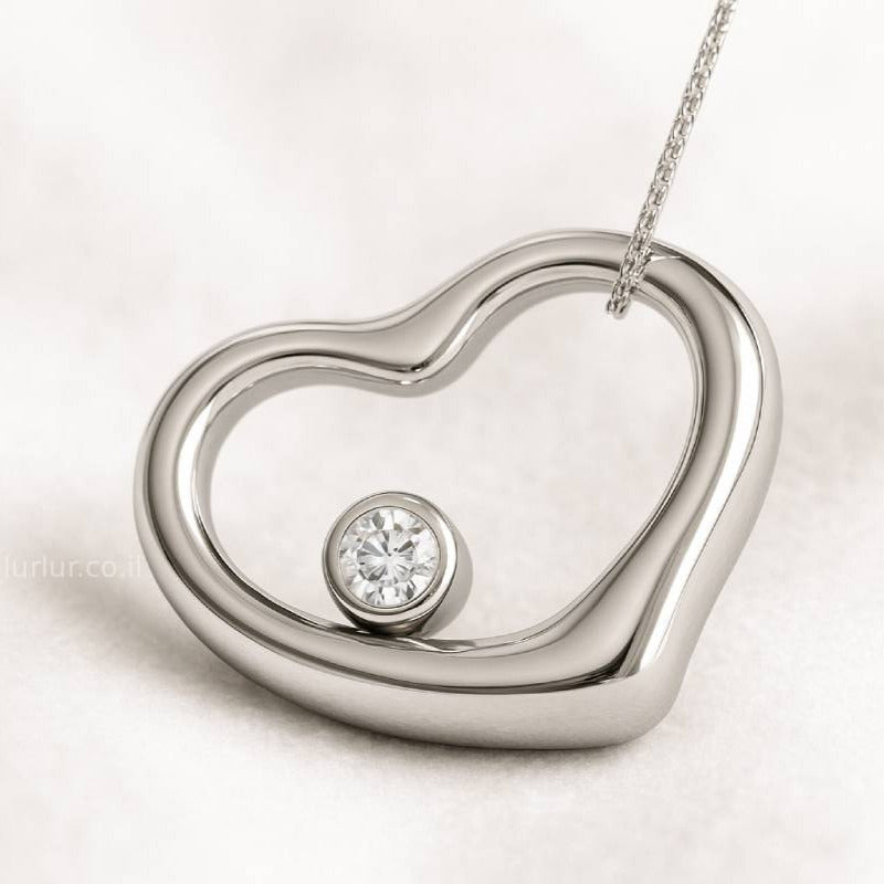Heart-shaped silver pendant with a diamond on a light background