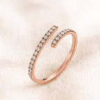 Rose gold ring with diamonds on a light pink background