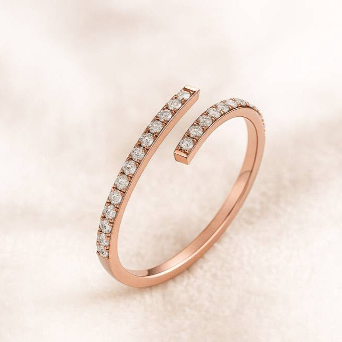 Rose gold ring with diamonds on a light pink background