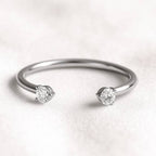 white gold ring with two diamonds on a light background
