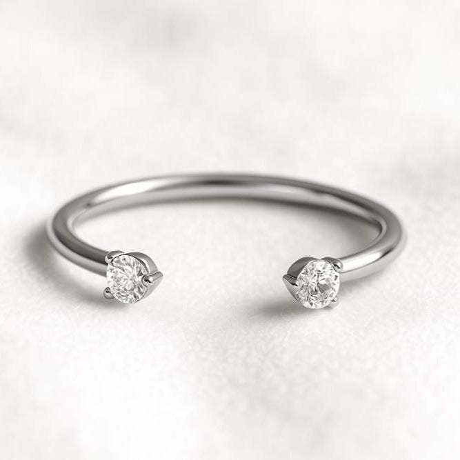 white gold ring with two diamonds on a light background