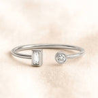gold ring with two diamond charms on a beige background