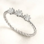 Diamond ring with three stones on a light background