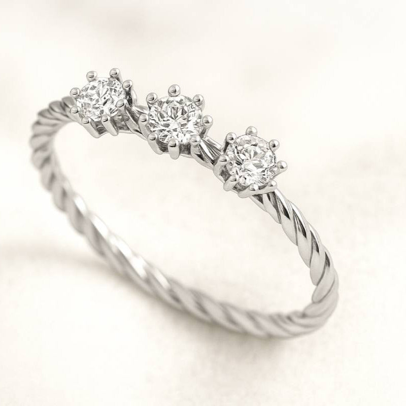 Diamond ring with three stones on a light background