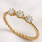Gold ring with three diamonds on a light background