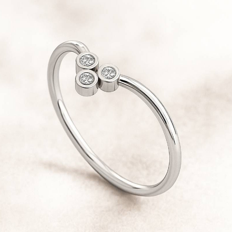 gold ring with three small diamonds on a light background