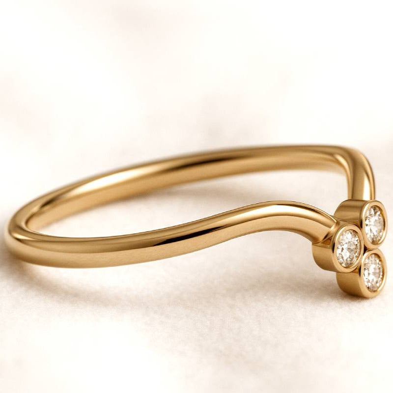 Gold ring with three diamonds on a light beige background