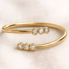 Gold ring with diamond accents on a soft beige background