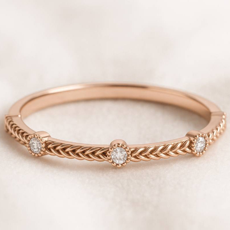 Rose gold ring with diamonds on a light beige background