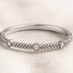 gold ring with intricate design on a light beige background