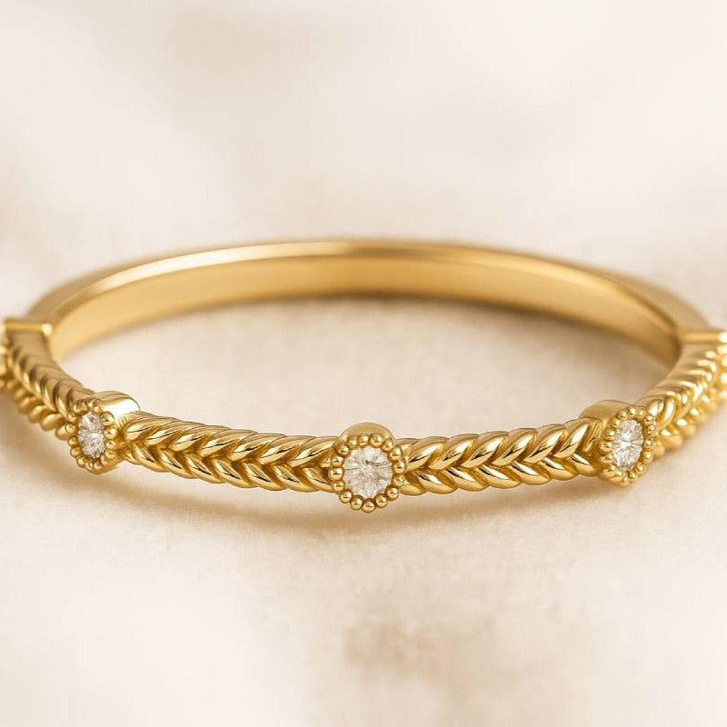 Gold ring with intricate design on a beige background