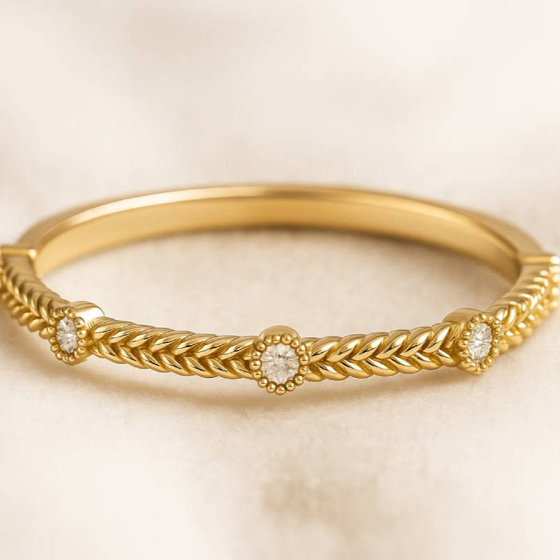 Gold ring with intricate design on a beige background