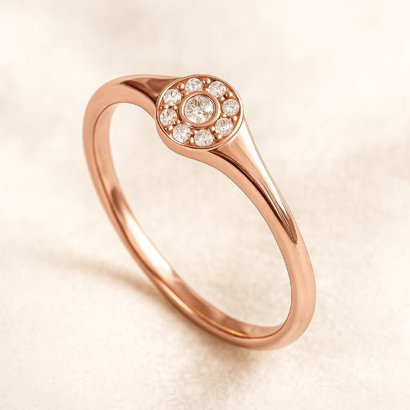 Rose gold ring with small diamonds on a beige background