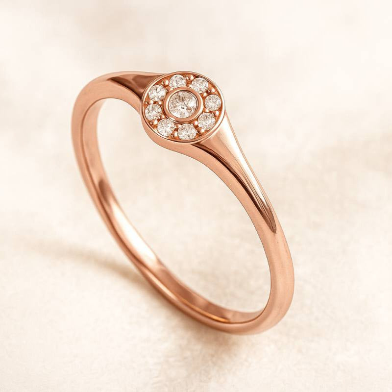 Rose gold ring with small diamonds on a beige background