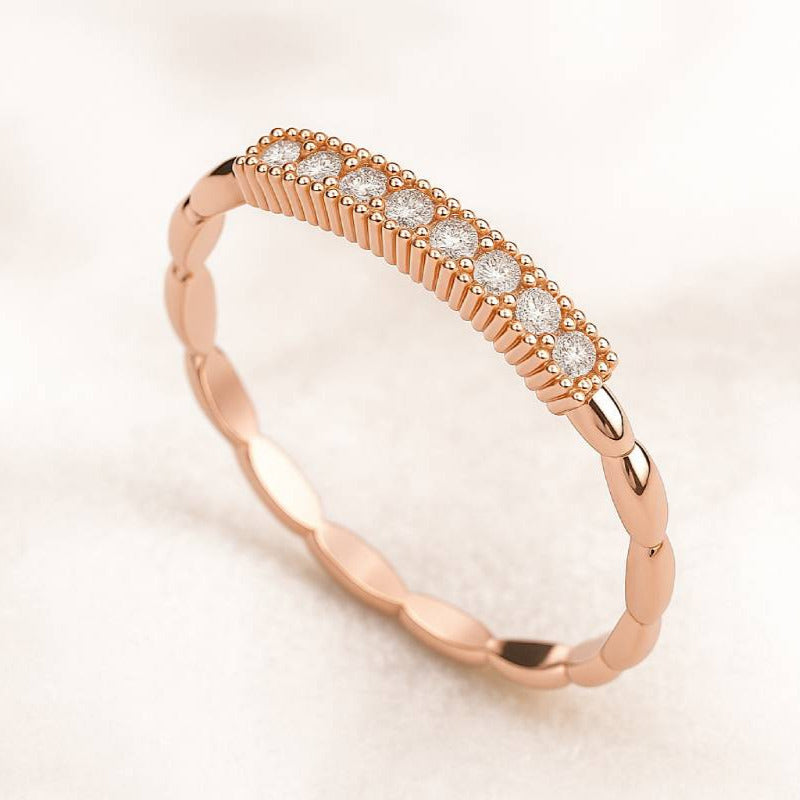 Rose gold ring with diamonds on a light background