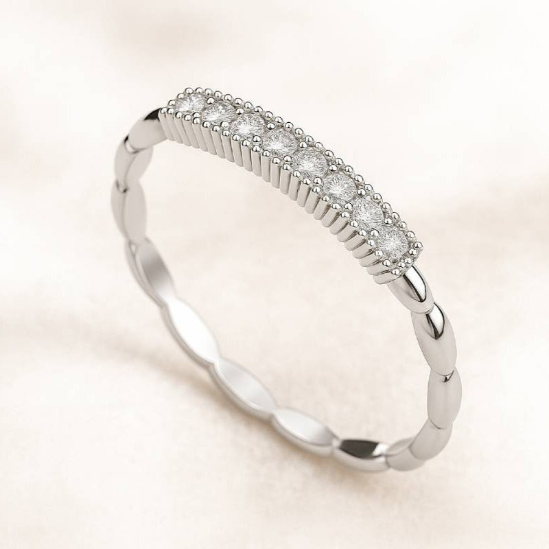 Gold ring with small diamonds on a light beige background