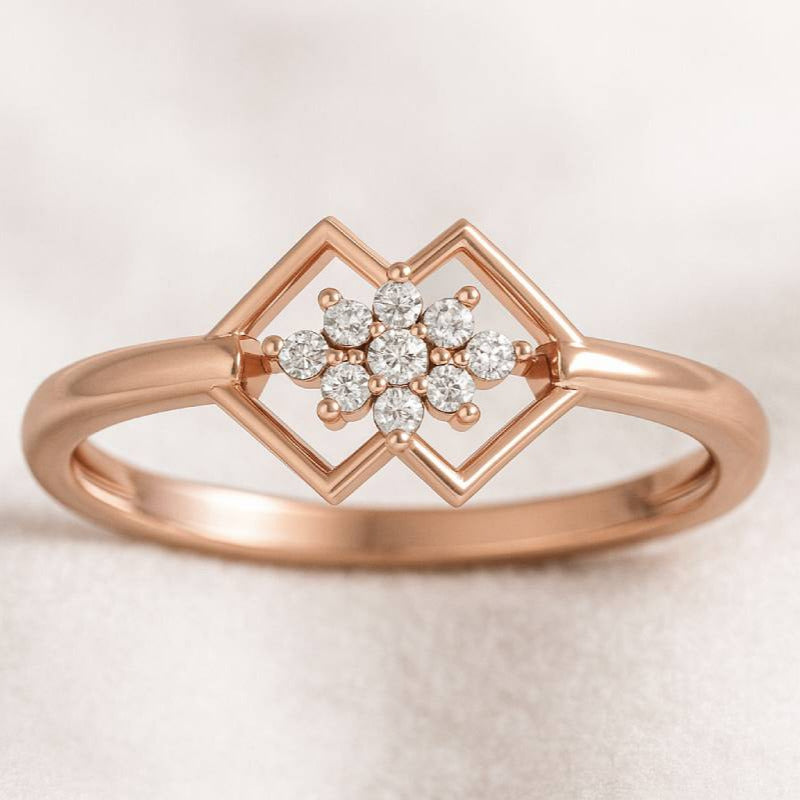 Rose gold ring with diamond flower design on a light background
