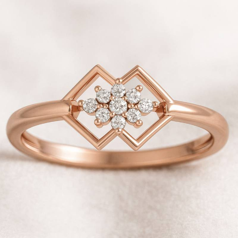Rose gold ring with diamond flower design on a light background