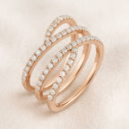 Rose gold ring with diamond accents on a light beige background