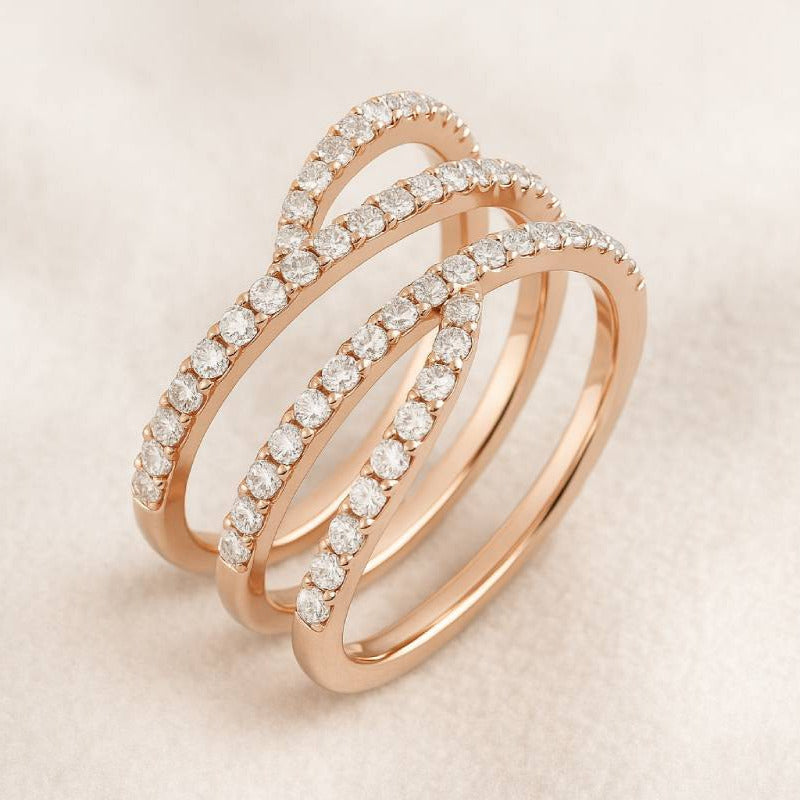 Rose gold ring with diamond accents on a light beige background