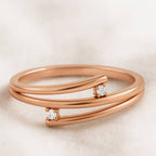 Rose gold ring with small diamonds on a beige background