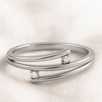 Gold ring with embedded diamonds on a light beige background