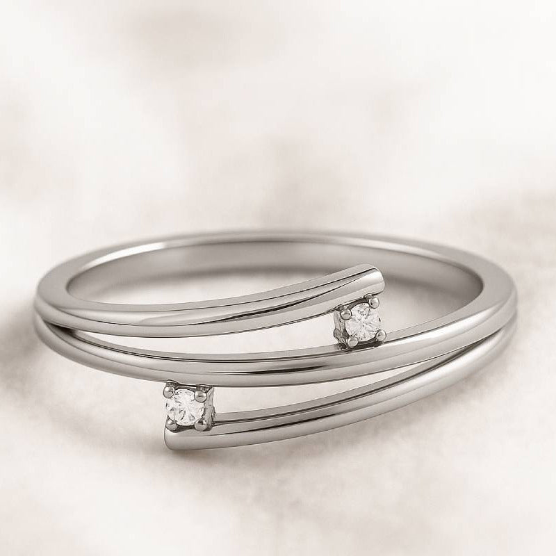 Gold ring with embedded diamonds on a light beige background