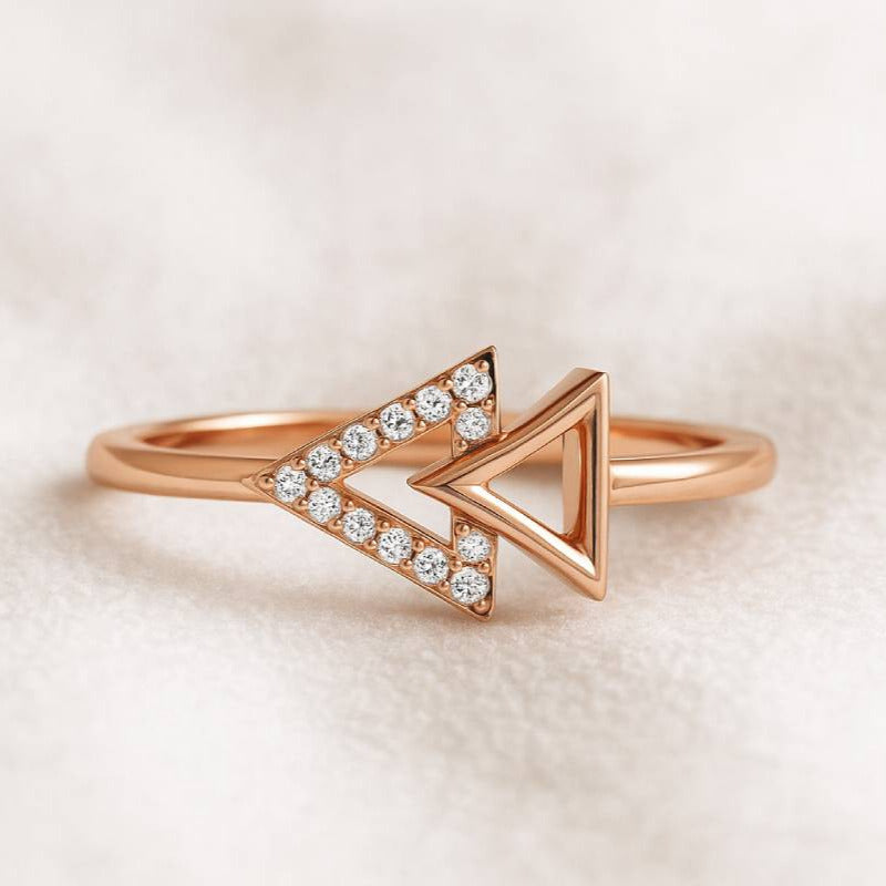 Rose gold ring with diamond accents on a light beige background
