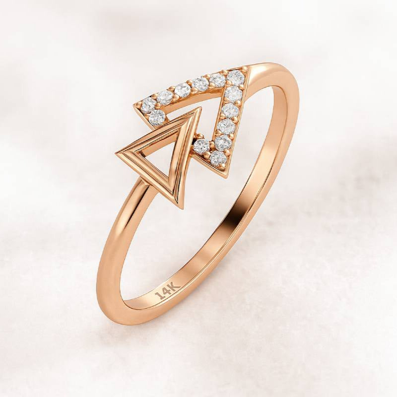 Rose gold ring with diamond accents on a light pink background