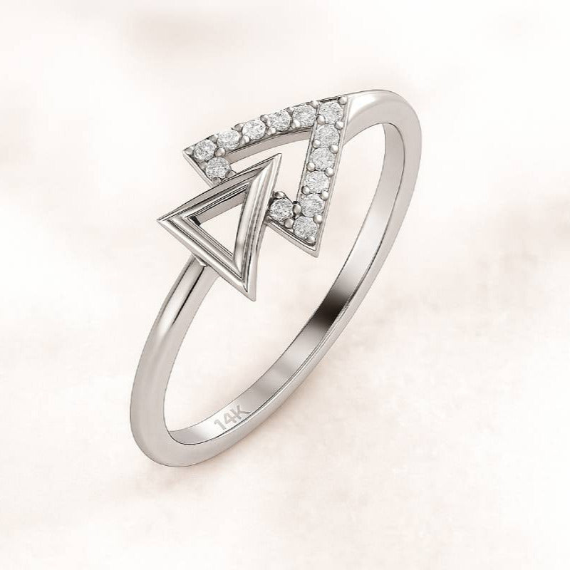 Gold ring with diamond accents on a light pink background