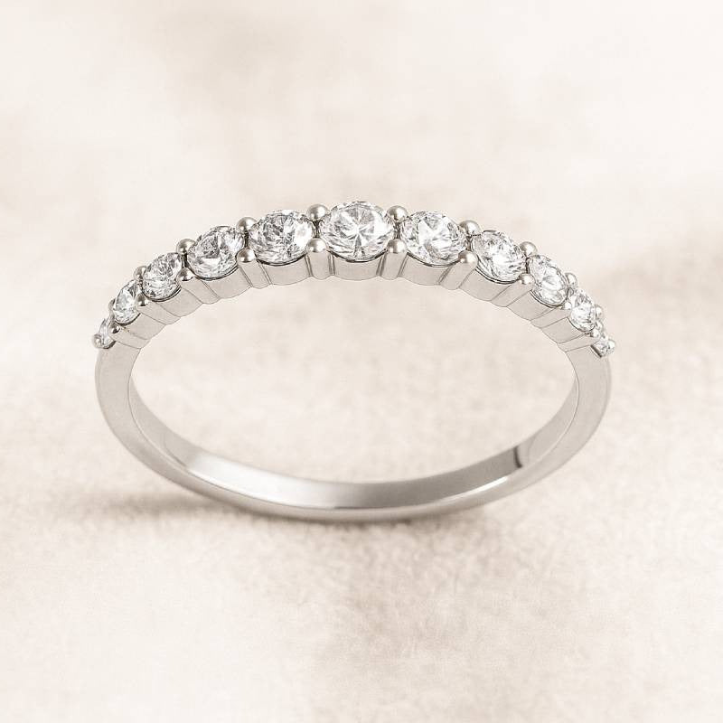 Gold ring with small diamonds on a light beige background