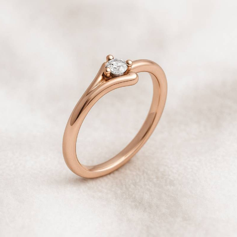 Rose gold ring with a diamond on a light beige background