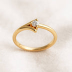 Gold ring with a diamond on a beige background