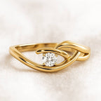 Gold ring with a diamond on a light beige background