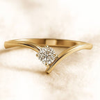 Gold ring with a diamond on a beige background