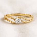 Gold ring with a diamond on a light beige background