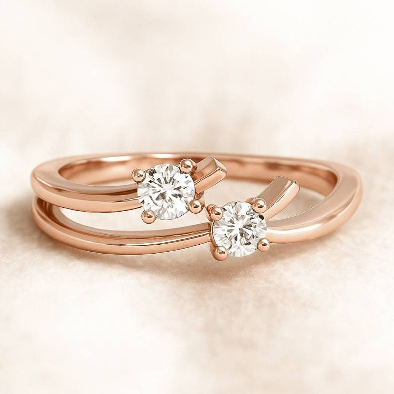 Rose gold ring with two diamonds on a beige background