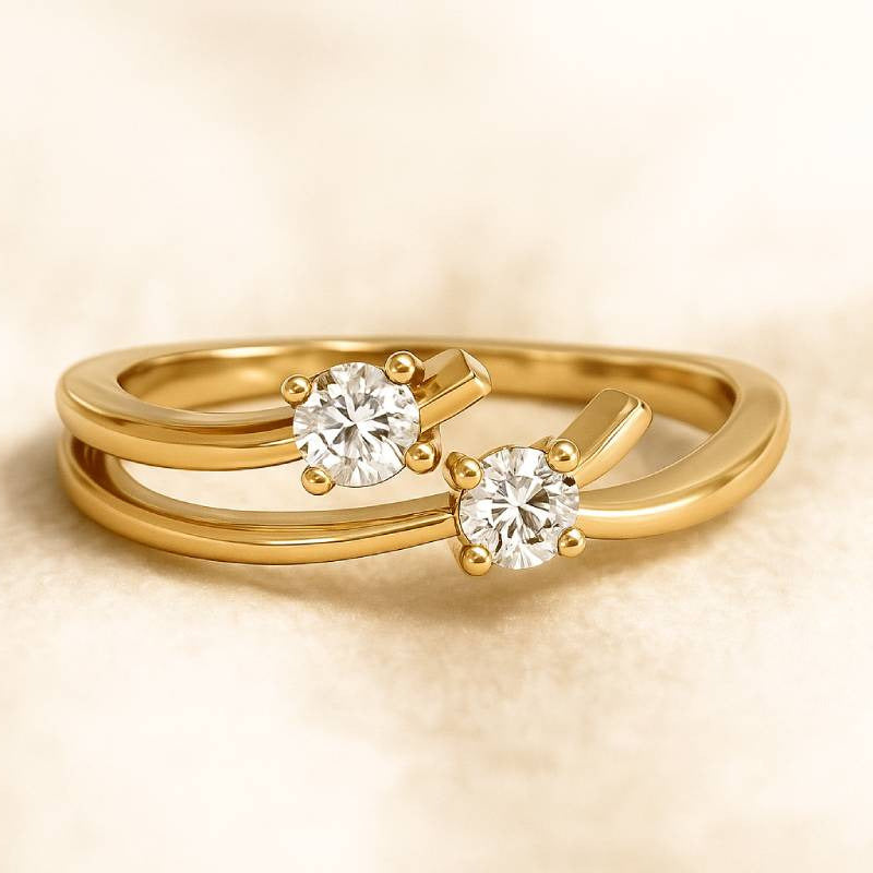 Gold ring with two diamonds on a beige background