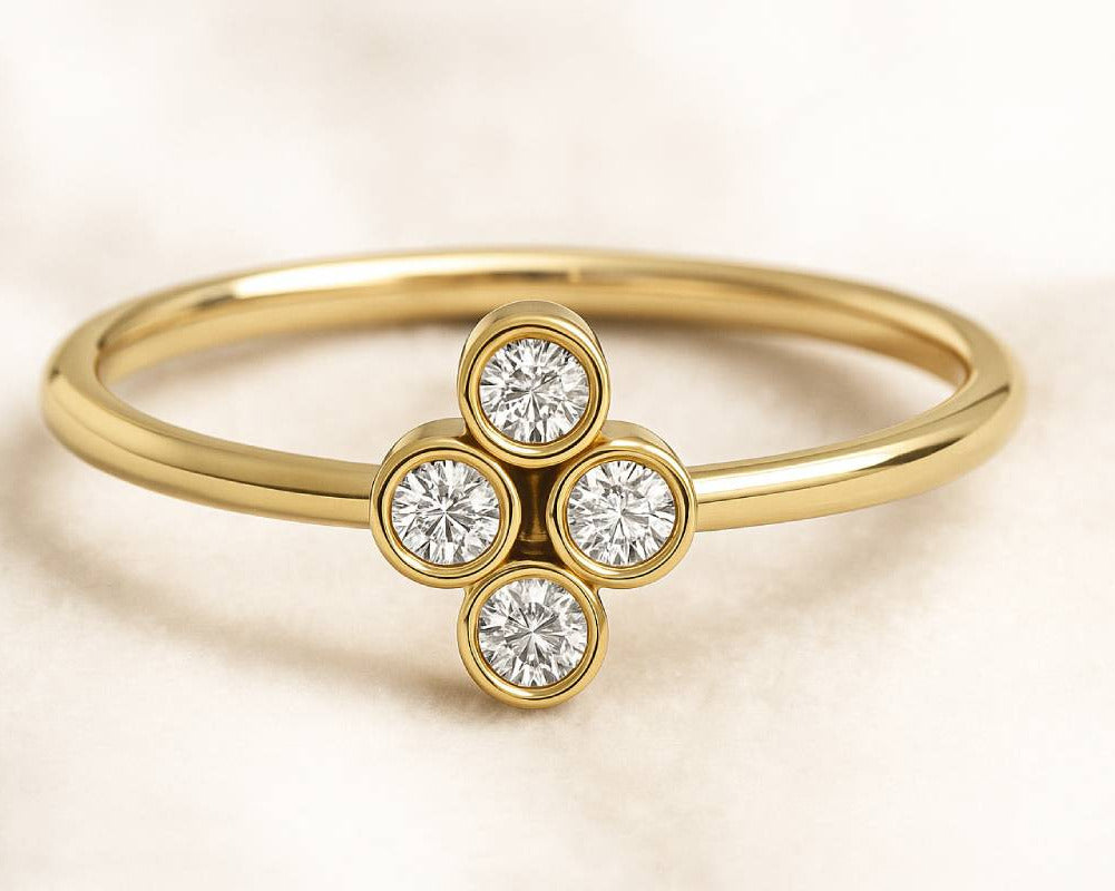 Gold ring with three diamond stones on a beige background