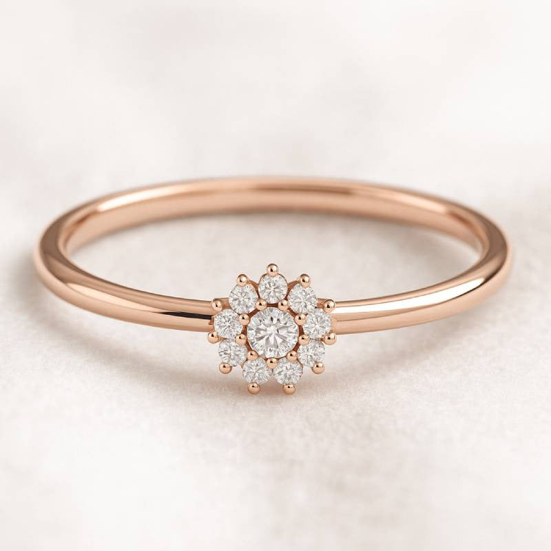 Rose gold ring with diamond flower design on a light background