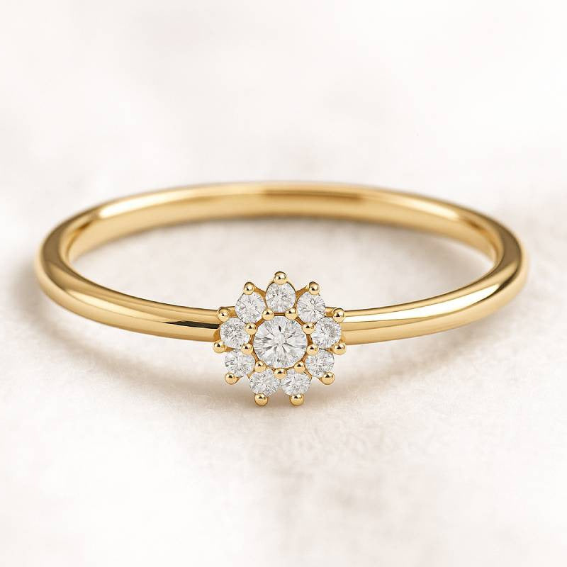 Gold ring with a diamond flower-shaped center on a light background