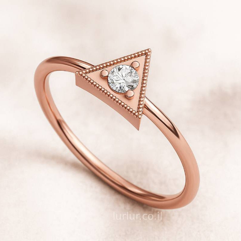 Rose gold ring with a diamond on a soft pink background
