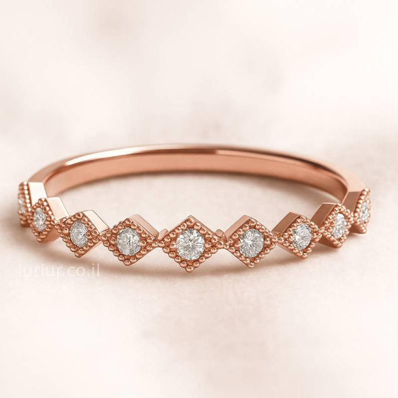 Rose gold ring with diamonds on a light pink background