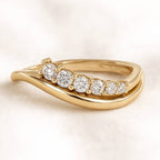 Gold ring with diamonds on a light beige background